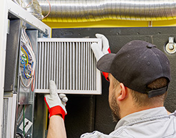 Belmar furnace repair technician changing an air filter